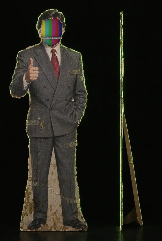 A cardboard news anchor standee with color bars for a face